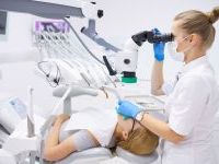 Pacjent na fotelu stomatologicznym poddający się badaniu.